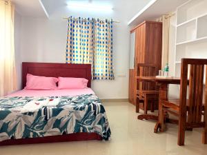 a bedroom with a bed and a desk in it at Nariman's riverstone hevan Resort in Kelakam