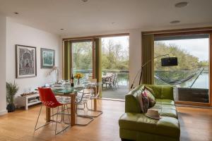 a living room with a table and a green couch at Goose Landing in South Cerney