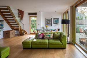 a living room with a green couch and a table at Goose Landing in South Cerney +37 photos
