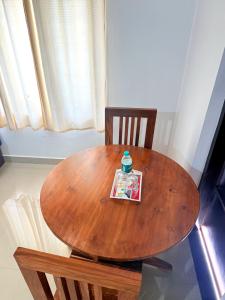 a wooden table and two chairs with a bottle on top at Nariman's riverstone hevan Resort in Kelakam +23 photos