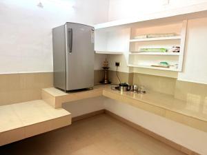 a kitchen with a stainless steel refrigerator and shelves at Nariman's riverstone hevan Resort in Kelakam