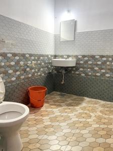 a bathroom with a toilet and a sink at Nariman's riverstone hevan Resort in Kelakam