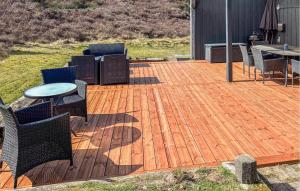a wooden deck with chairs and a table on it at Holiday Home Ringvejen Rømø Iv in Rømø