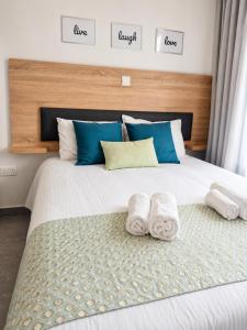 a bedroom with a large bed with towels on it at Green Bay Suites in Protaras