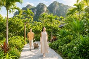 a man and a woman walking down a walkway at Aman Retreat Ninh Binh in Ninh Binh