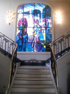 a staircase with a large stained glass window at Chambre Eugénie in Saint-Cloud
