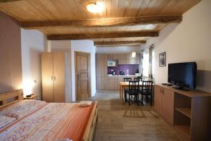 a bedroom with a bed and a dining room at Pension U Řehoutů in Horní Planá