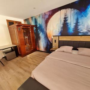 a bedroom with a bed and a painting on the wall at Domaine du Cardou in Puy-lʼÉvêque