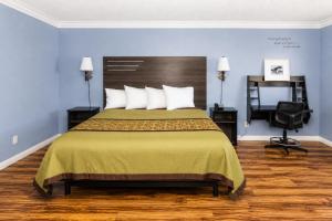 a bedroom with a bed and a desk and a chair at Big A Motel & Suites Near Disneyland Orange County in Orange