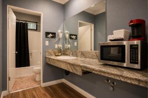 a bathroom with a sink and a microwave on a counter at Big A Motel & Suites Near Disneyland Orange County in Orange