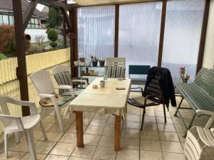 eine Terrasse mit Tisch und Stühlen und Fenstern in der Unterkunft Edoris in Kraichtal