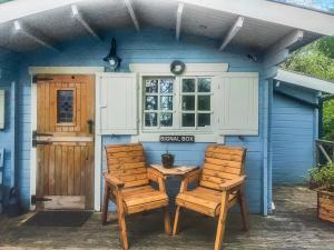 two chairs and a table in front of a blue house at The Signal Box in Girvan