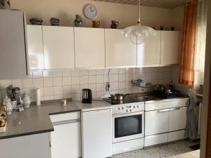 eine Küche mit weißen Schränken und einem Herd mit Backofen in der Unterkunft Edoris in Kraichtal + 3 Fotos