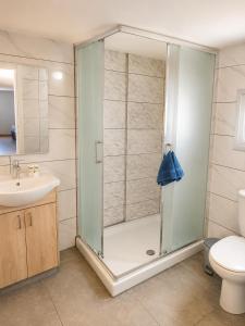 a bathroom with a shower with a toilet and a sink at Green Bay Suites in Protaras