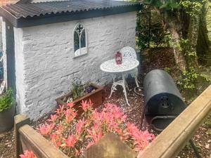 a small garden with a table and a small building at The Signal Box in Girvan +5 photos