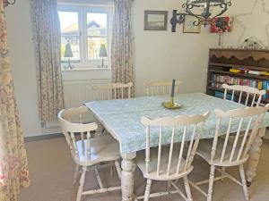 a dining room table with four chairs and a blue table at Willow Cottage in Framlingham