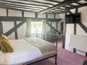 a bedroom with a bed and a large window at Willow Cottage in Framlingham