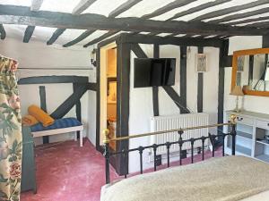 a bedroom with a bed and a tv on the wall at Willow Cottage in Framlingham