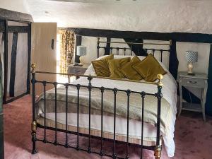a bedroom with a bed with a black and white comforter at Willow Cottage in Framlingham +14 photos