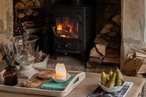 a candle sitting on a table in front of a fireplace at Hill View in Burford