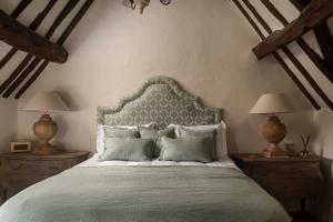 a bedroom with a large bed with two lamps on tables at Hill View in Burford
