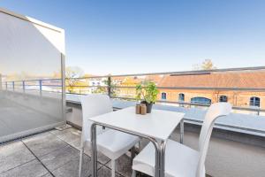 a white table and chairs on a balcony with a view at first Apart in Erlangen