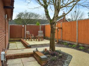 a patio with a tree and a table and chairs at The Squirrels in Great Malvern