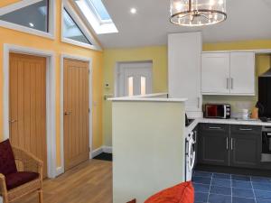 a kitchen with white cabinets and a skylight at The Squirrels in Great Malvern +5 photos