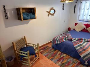 a bedroom with a bed and a chair and a mirror at Tigmi Blue - Imsouane Surf et Océan in Imsouane