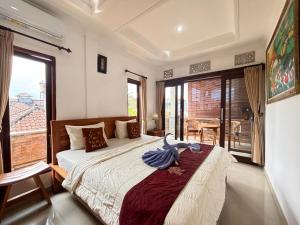 a bedroom with a large bed and a balcony at Wahadi homestay in Ubud +26 photos