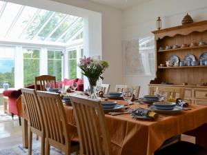 a dining room with a table with chairs and a window at Trevene in Buttermere