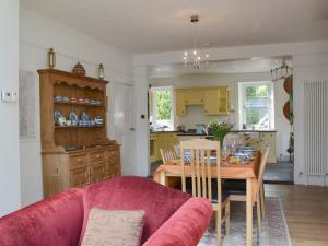 a kitchen and dining room with a pink couch and a table at Trevene in Buttermere