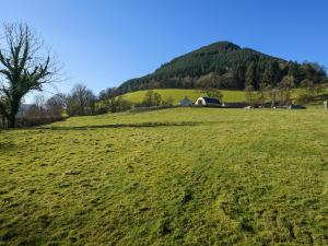 a green field with a house on top of a hill at Creyr Glas Pod -Uk41796 in Hirnant +26 photos