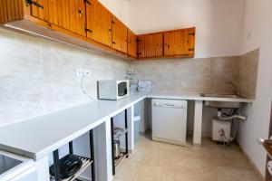 a kitchen with a white counter and a microwave at Kosta Villa Alykes in Lefkimmi +17 photos