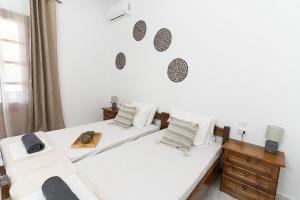 two beds in a room with white walls at Kosta Villa Alykes in Lefkimmi