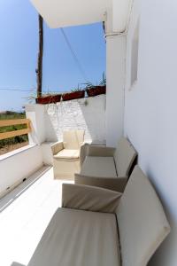 a balcony with two chairs and a window at Kosta Villa Alykes in Lefkimmi