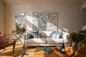 a living room with a white couch and a large painting at Summer Lake in South Cerney