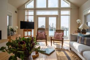 a living room with a couch and chairs and a tv at Summer Lake in South Cerney