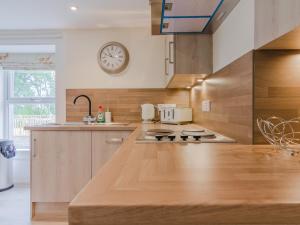 a kitchen with a stove and a clock on the wall at Dalnaglar Cottage - Uk30260 in Cray