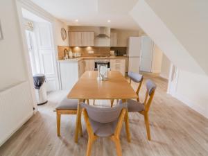 a kitchen and dining room with a wooden table and chairs at Dalnaglar Cottage - Uk30260 in Cray +22 photos