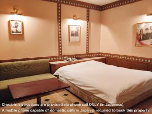 a hospital room with a bed and a chair at アネックス艶 -大人専用- in Fuefuki