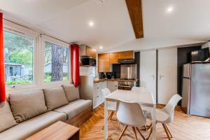 a living room with a couch and a table at Mobil-home Badji in Gastes