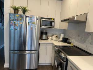 a kitchen with a stainless steel refrigerator and a stove at Tide Manor in Markham