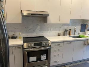 a kitchen with white cabinets and a stove top oven at Tide Manor in Markham