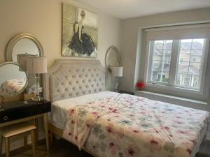 a bedroom with a bed and a mirror and a window at Tide Manor in Markham