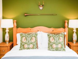 a bedroom with a green wall and a bed with two lamps at Carters Cottage - Ukc3947 in Puncknowle +44 photos
