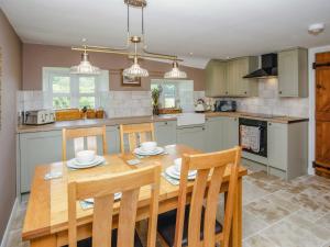 a kitchen with a wooden dining room table and chairs at Thatcher's Cottage - Ukc3956 in Puncknowle