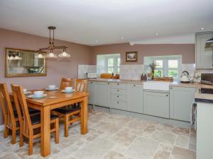a kitchen with a wooden table and chairs at Thatcher's Cottage - Ukc3956 in Puncknowle