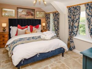 a bedroom with a large bed with red pillows at Thatcher's Cottage - Ukc3956 in Puncknowle
