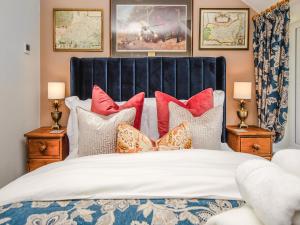 a bedroom with a bed with red and white pillows at Thatcher's Cottage - Ukc3956 in Puncknowle +23 photos
